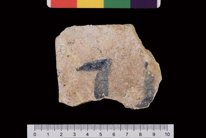 Fragmento de verso de azulejo com vestígio de numeração pintada para auxílio de montagem - verso